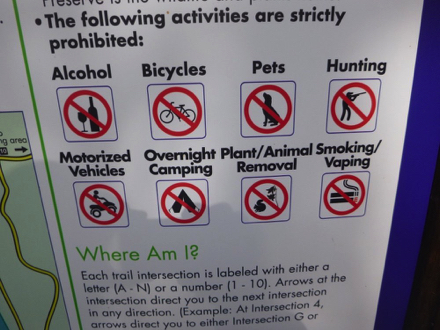 Sign – Strictly prohibited: alcohol, pets, biking, hunting, vehicles, camping, removing plants/animals, smoking
